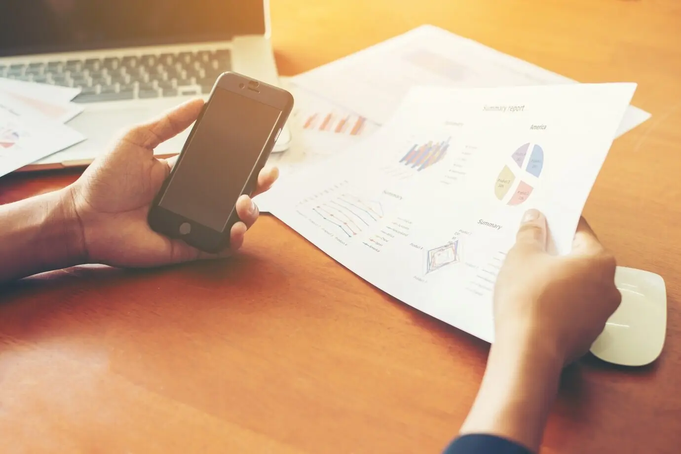 Hands together with a smartphone and documents