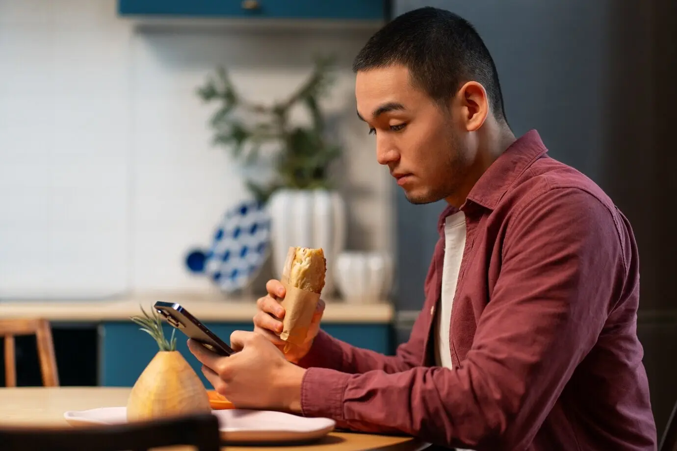 Medium shot of a man with a paper-wrapped sandwich.